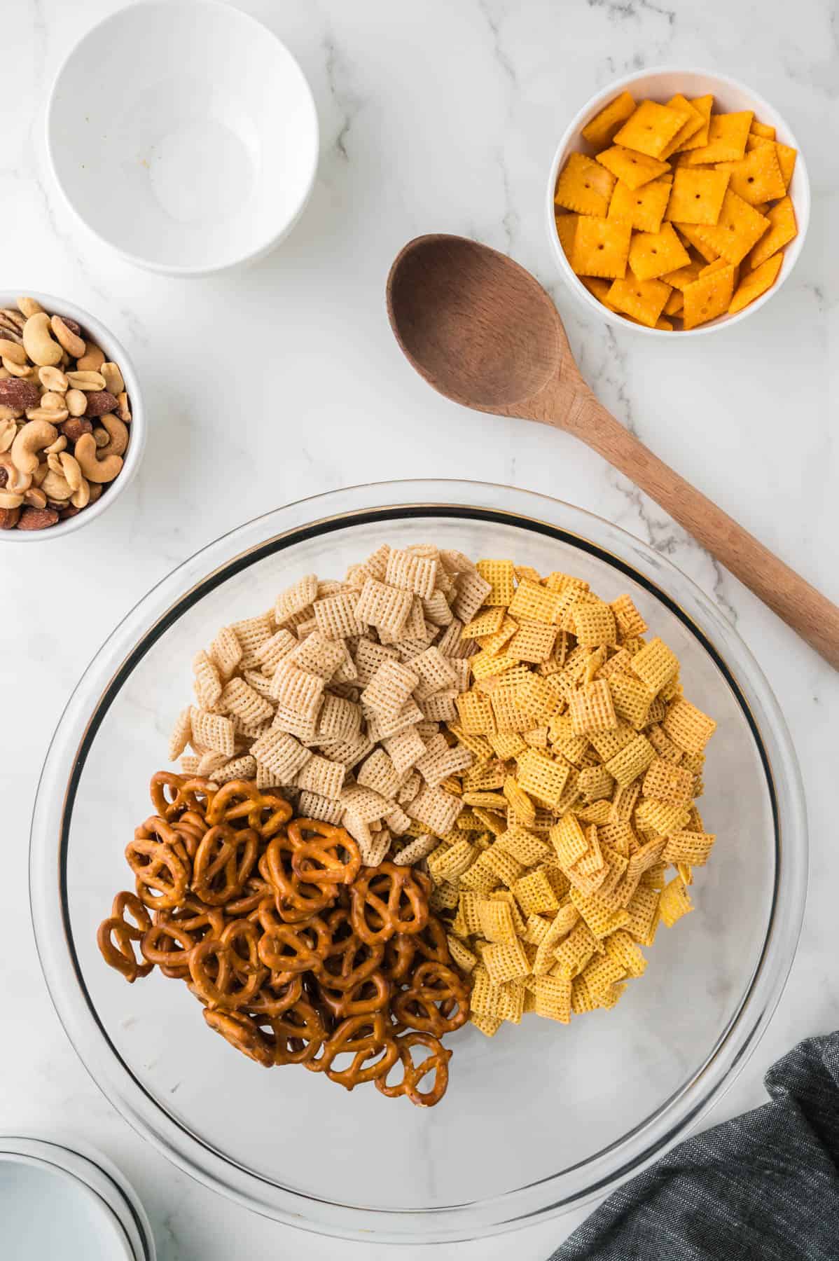 Combining chex mix ingredients in a large bowl.