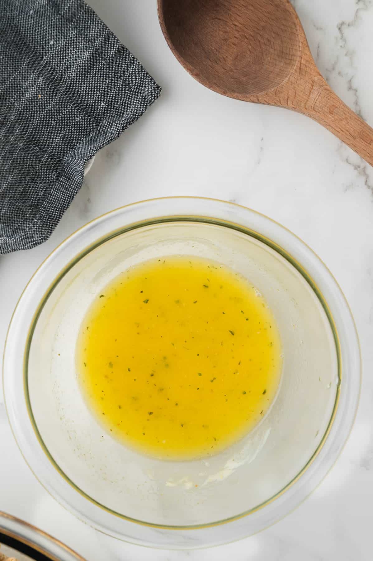 Melted butter and seasonings in a glass bowl.