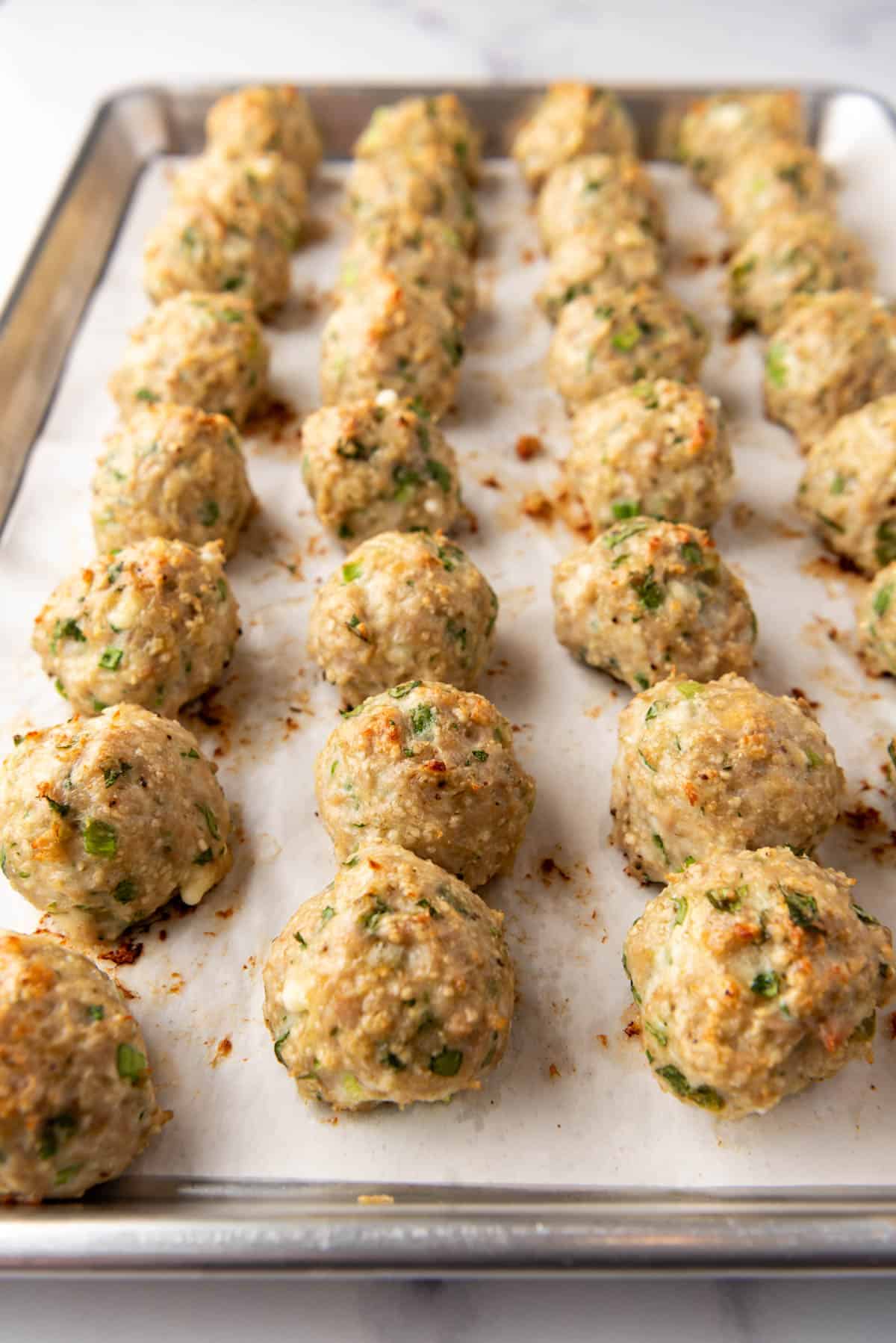 A close up image of baked chicken meatballs.