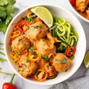 An overhead image of a bowl of coconut curry chicken meatballs.