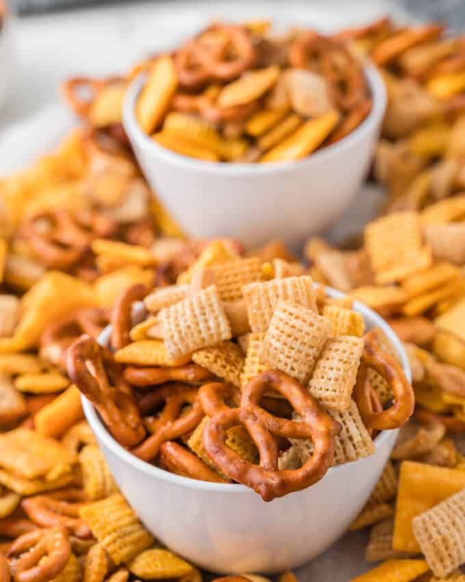 Two white bowls piled with Chex mix.