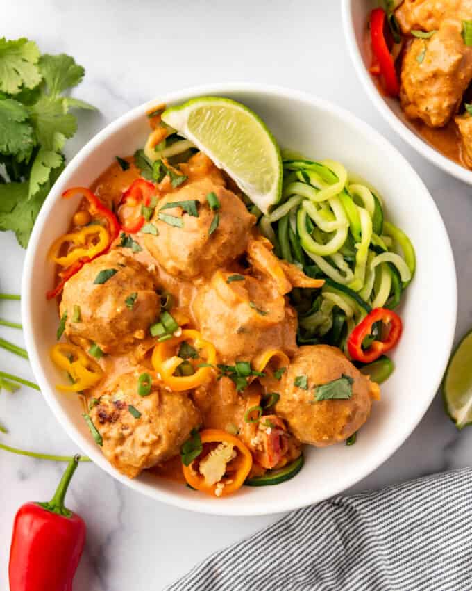 An overhead image of a bowl of coconut curry chicken meatballs.