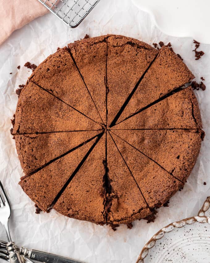 An overhead image of a sliced flourless chocolate cake.