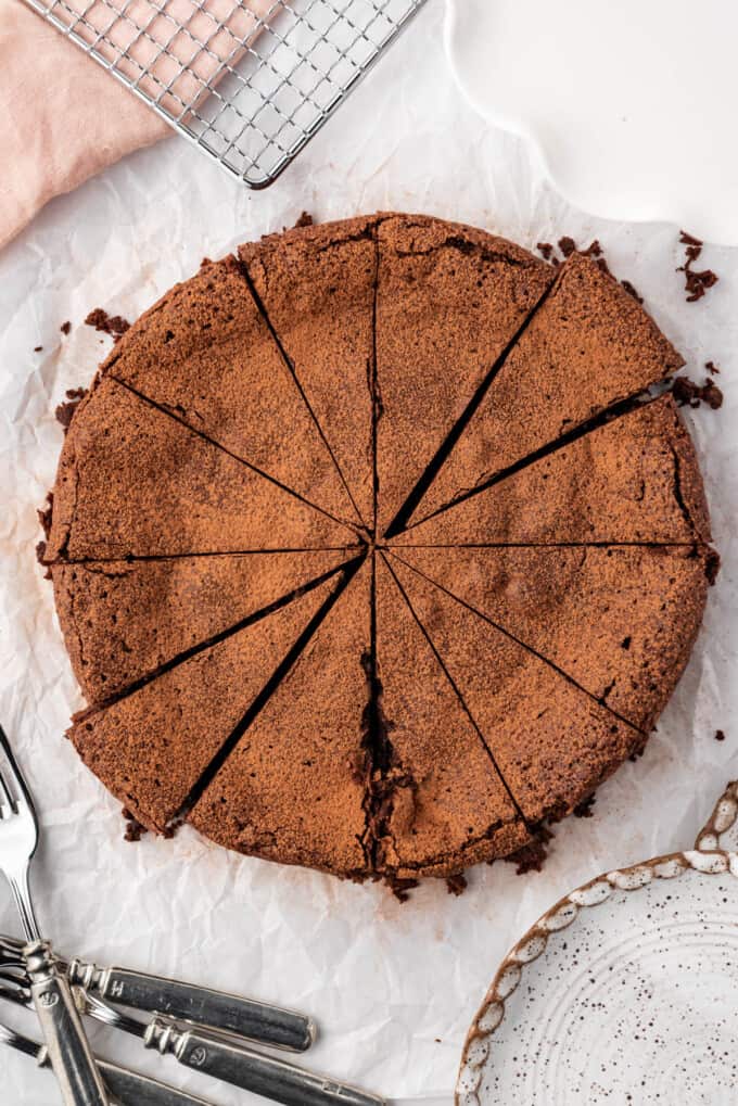 An overhead image of a sliced flourless chocolate cake.