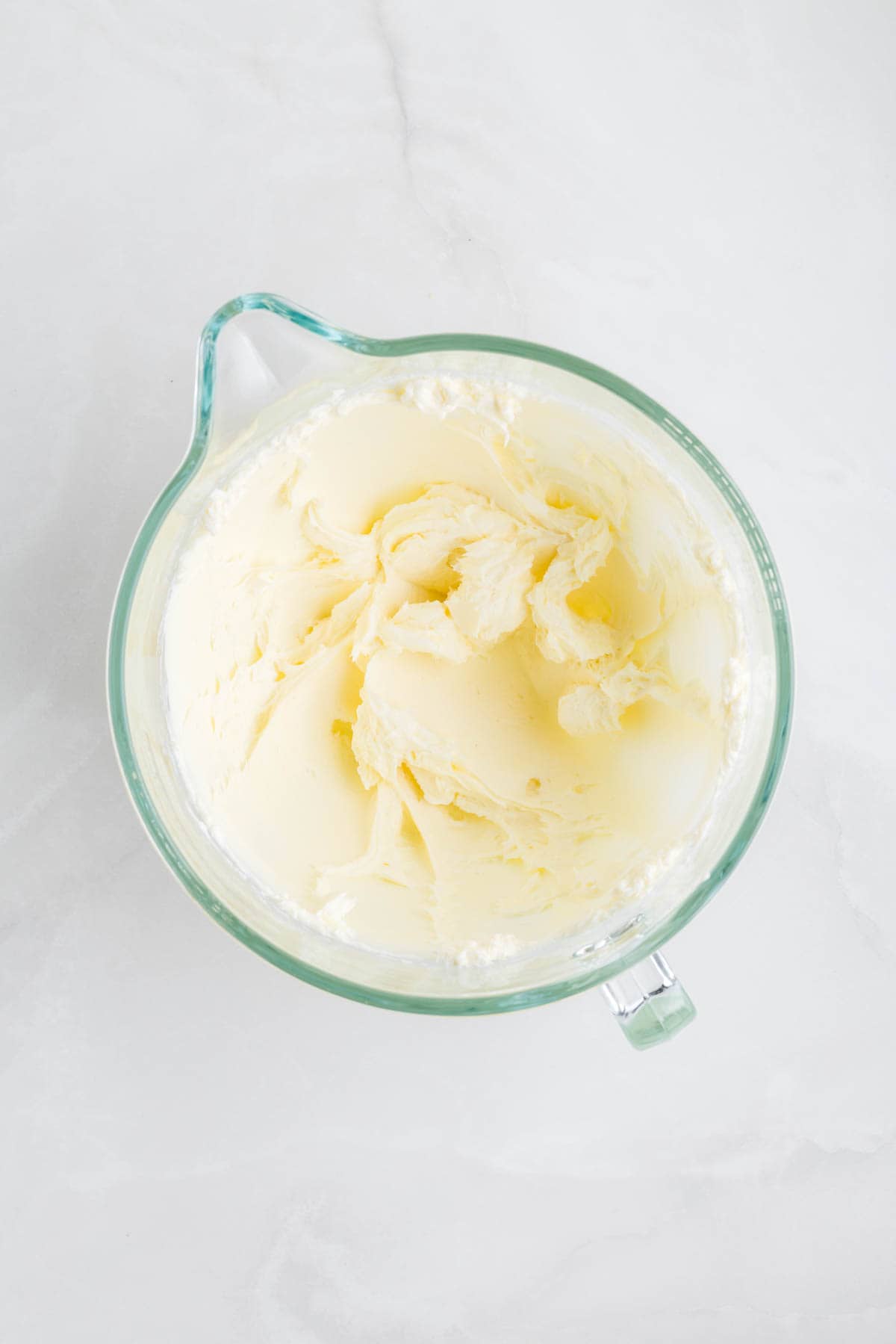 Softened cream cheese mixed with sugar in a large mixing bowl.