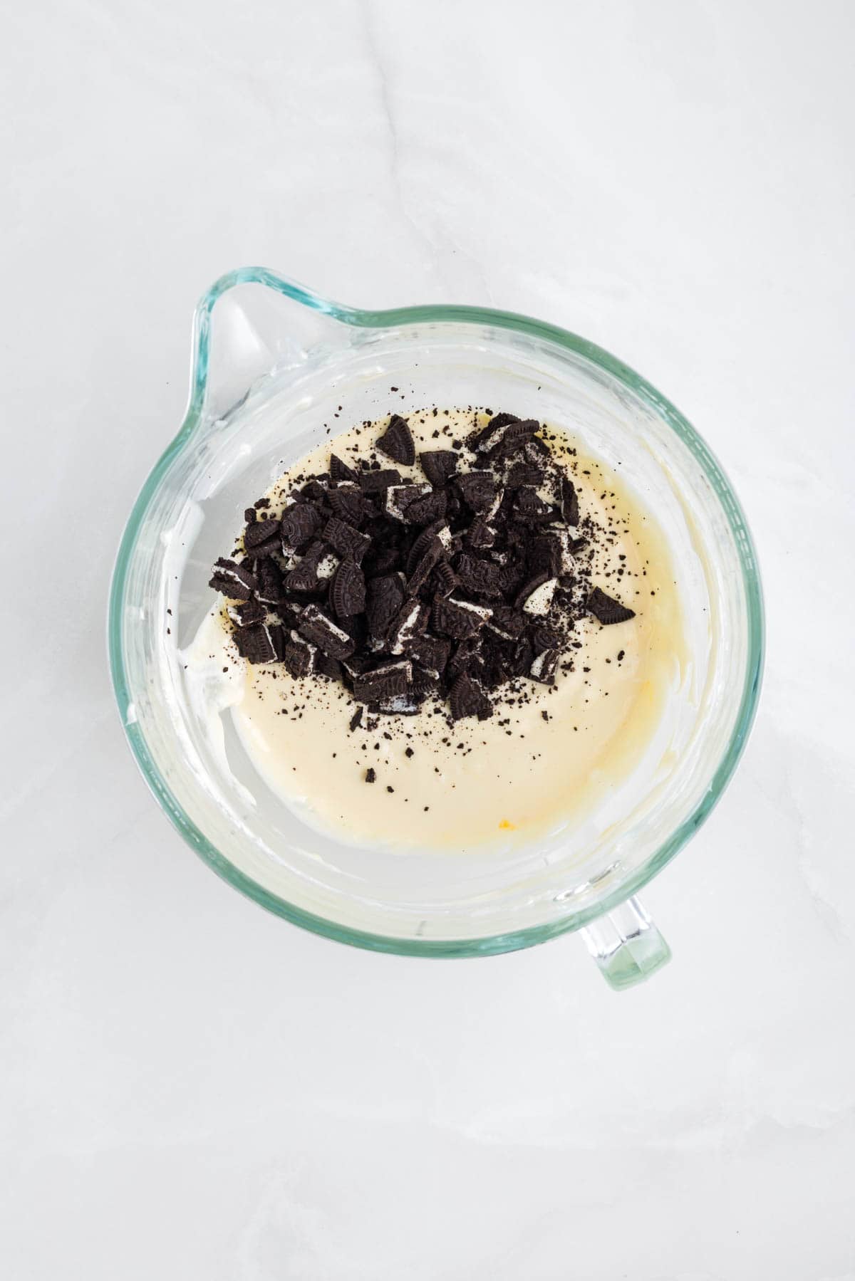 Adding broken up Oreo cookies to cheesecake batter.