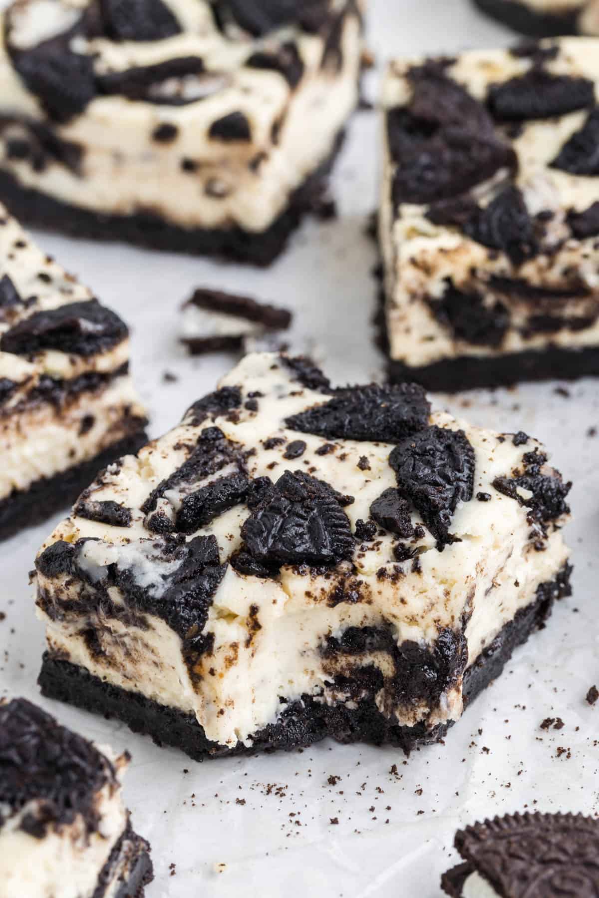 An Oreo cheesecake bar with a bite taken out of it.