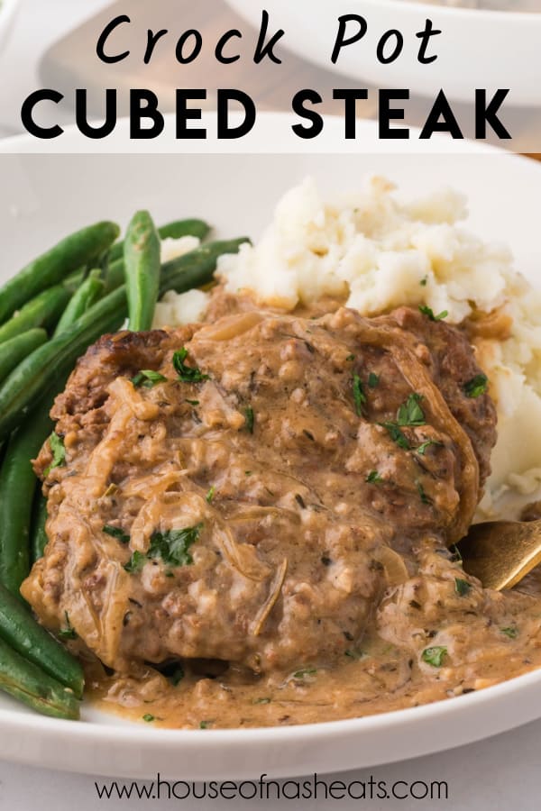 Crock pot cubed steak on a plate with mashed potatoes with text overlay.