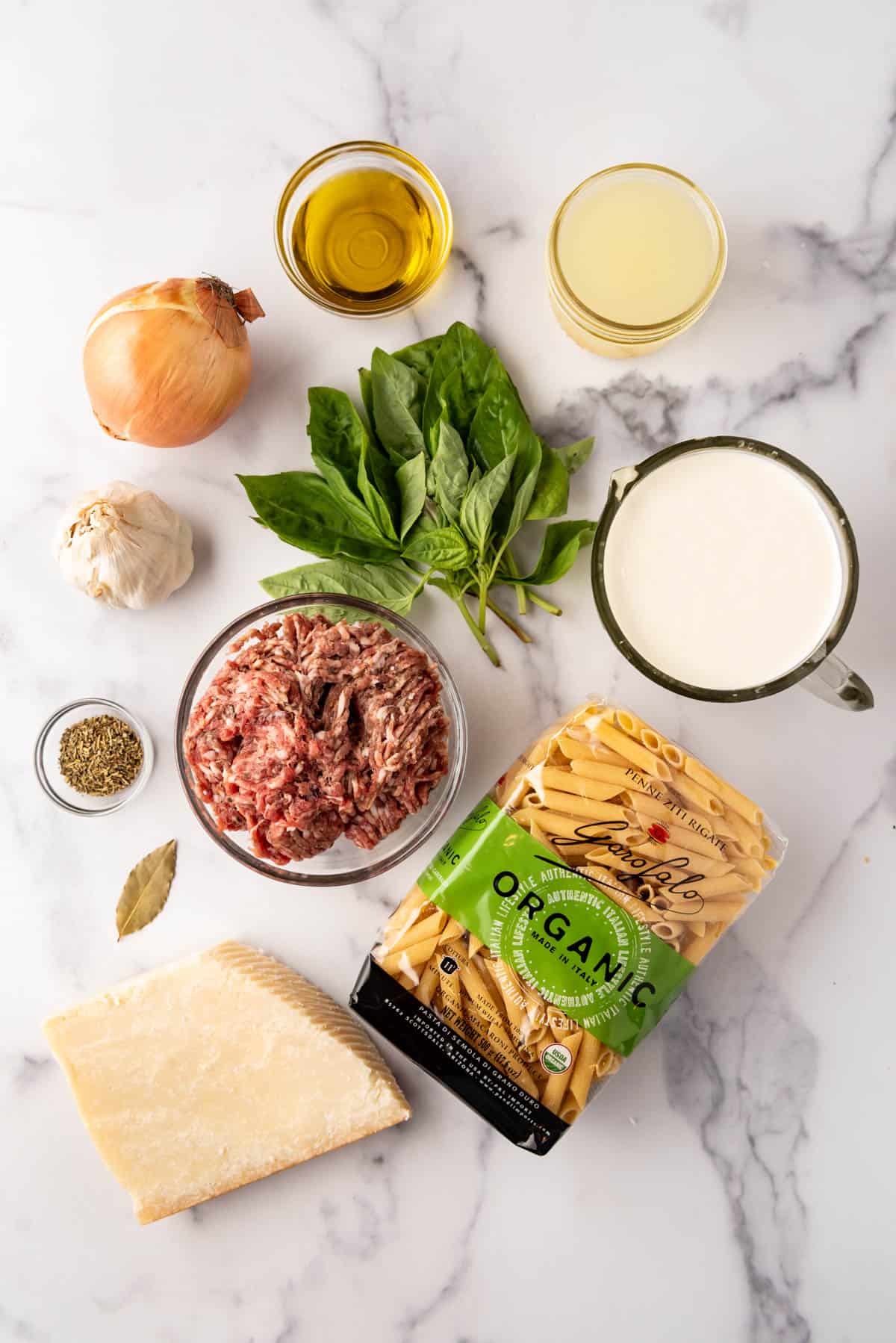 An overhead image of ingredients for creamy Italian sausage pasta.