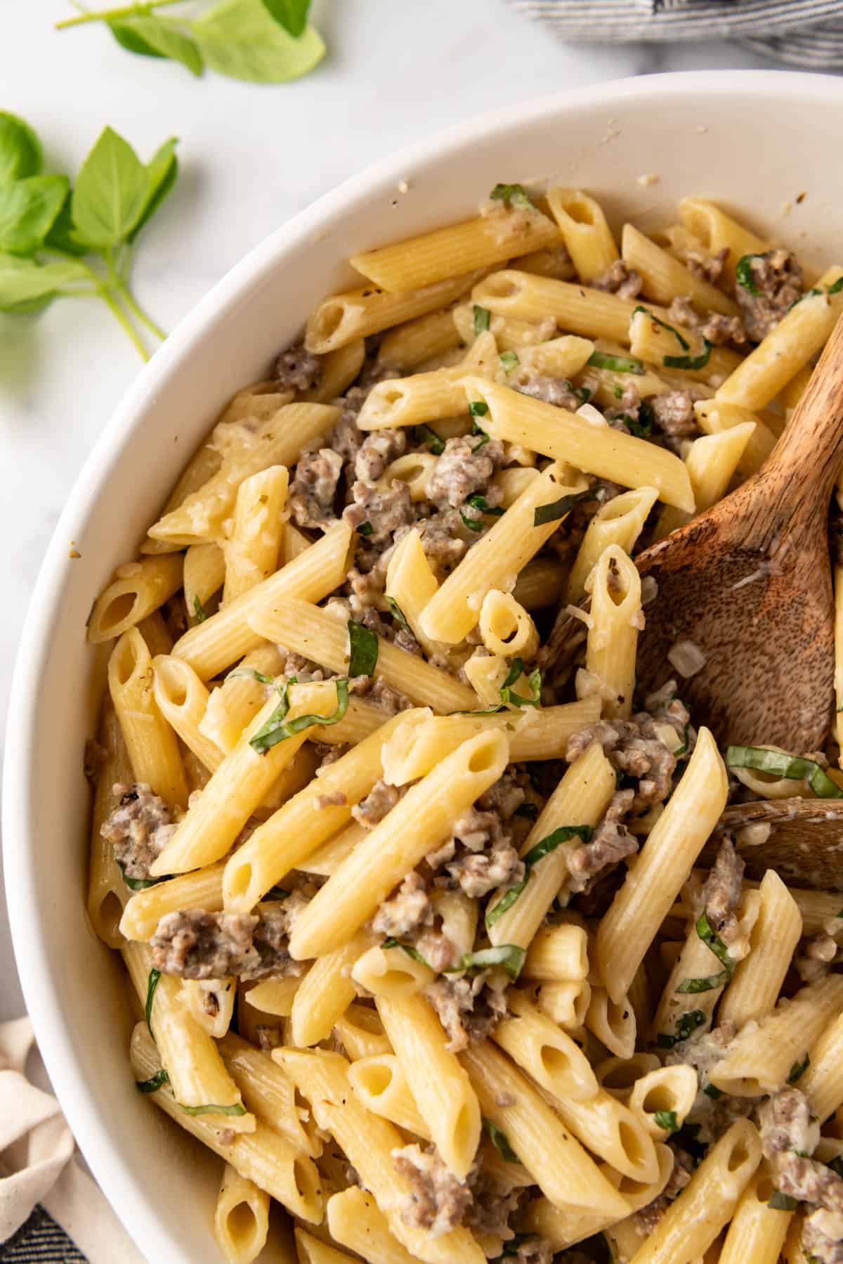 A close image of cooked penne pasta with Italian sausage.