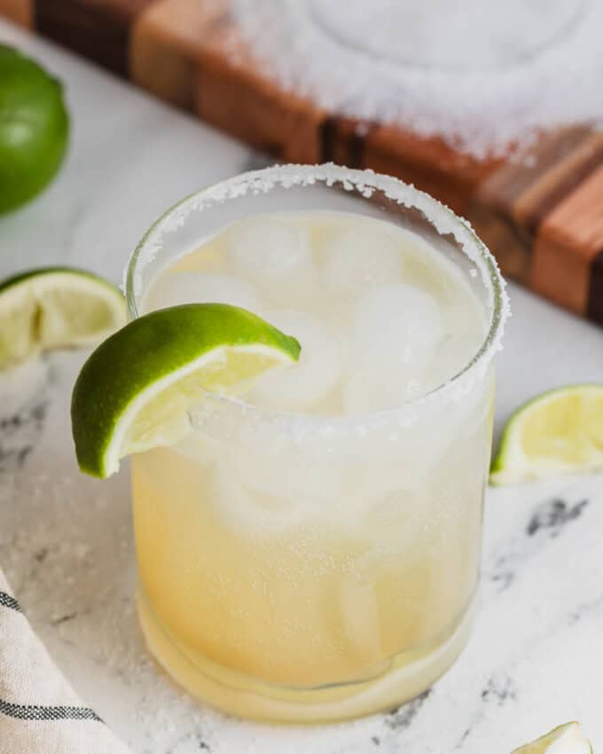 A margarita mocktail next to limes.