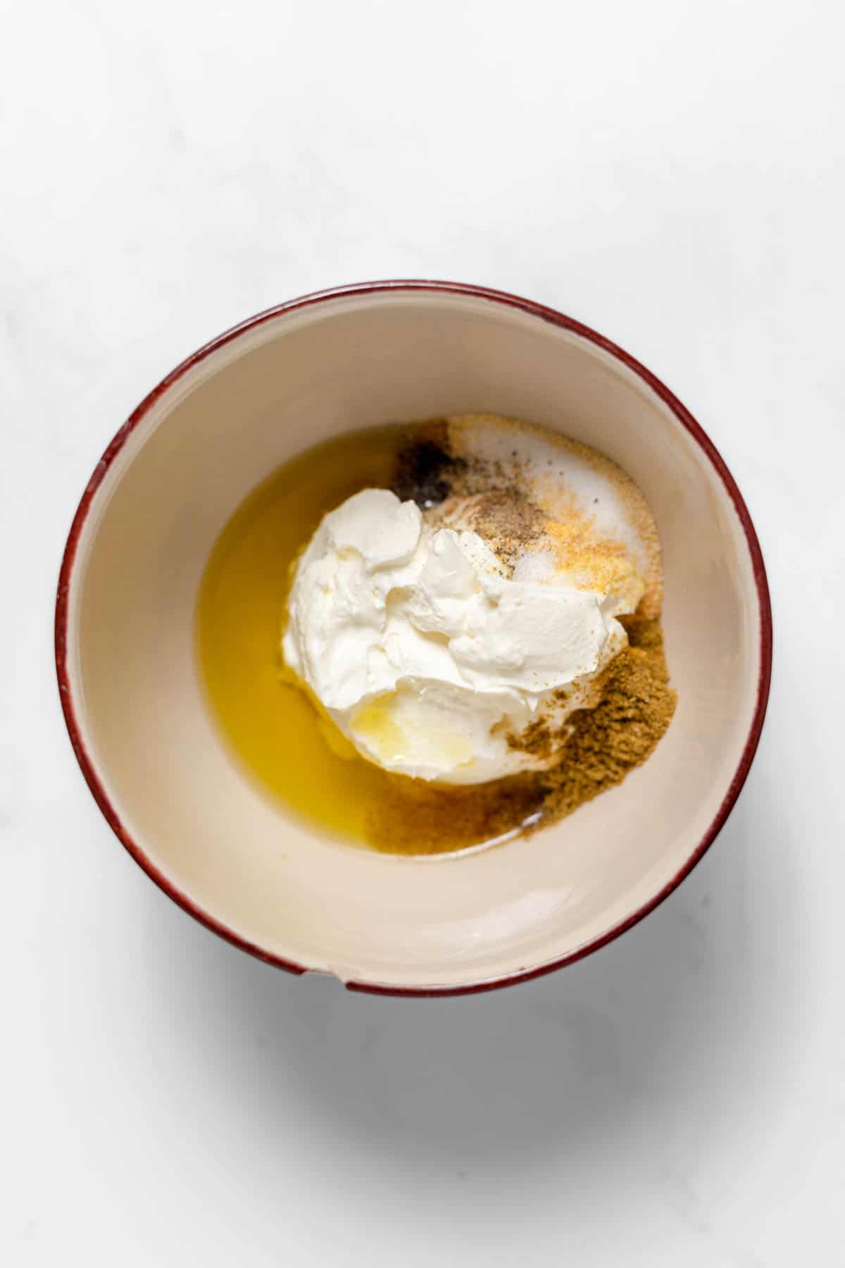 Combining ingredients in a bowl to make a creamy dressing for Frito corn salad.