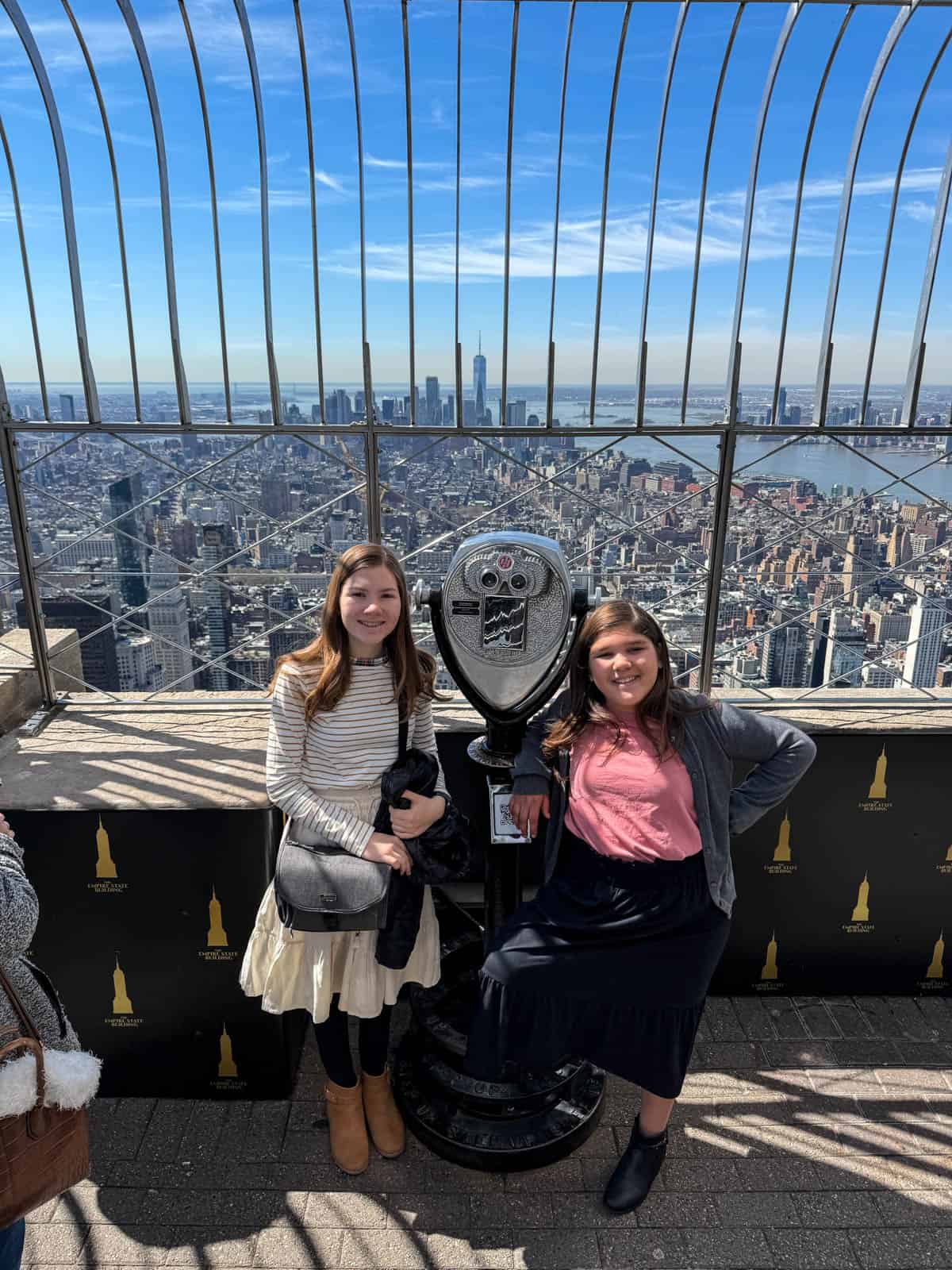Two girls on the top of the Empire State Building in NYC.