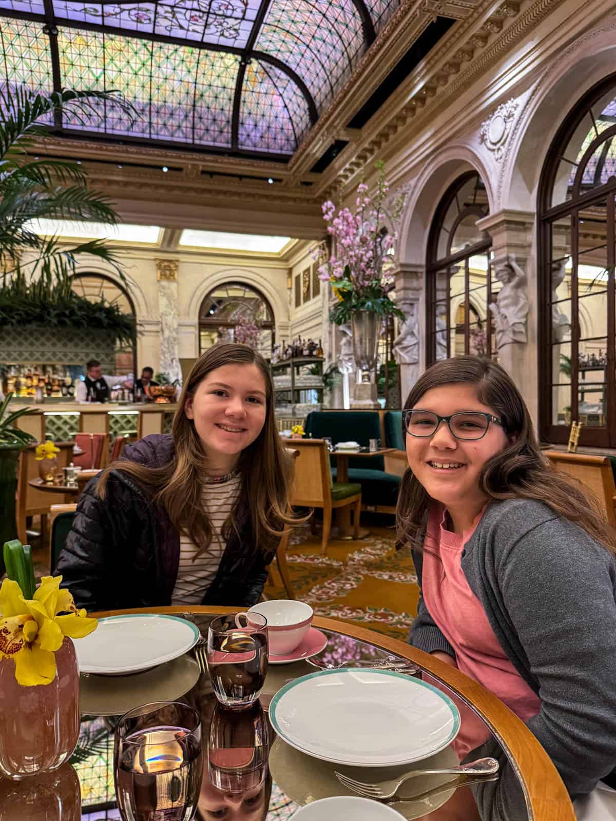 Two girls having the Eloise tea at the Plaza Hotel in the Palm Court.