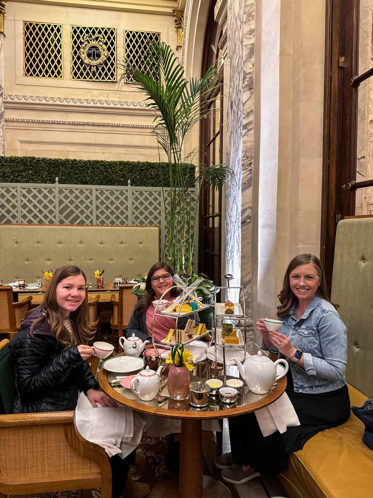 A mom and two young daughters having tea at the Plaza Hotel in NYC.