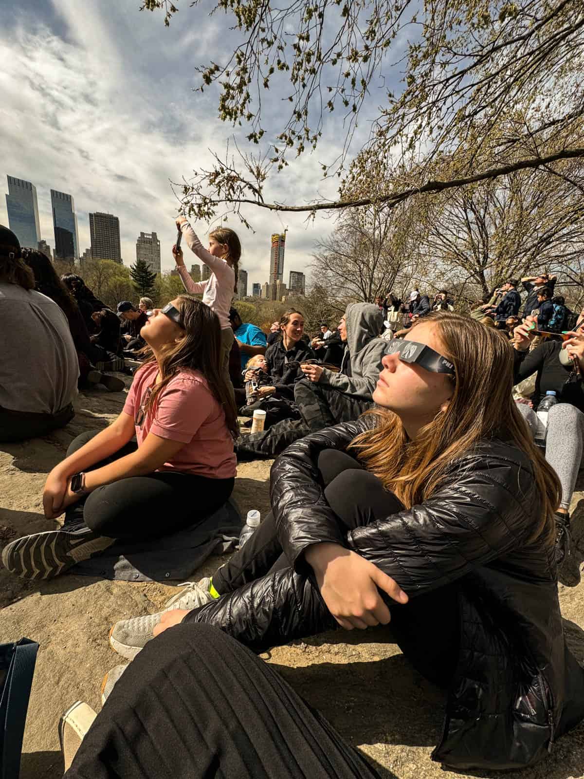 People wearing eclipse glasses watching the solar eclipse in New York Central Park in April 2024.