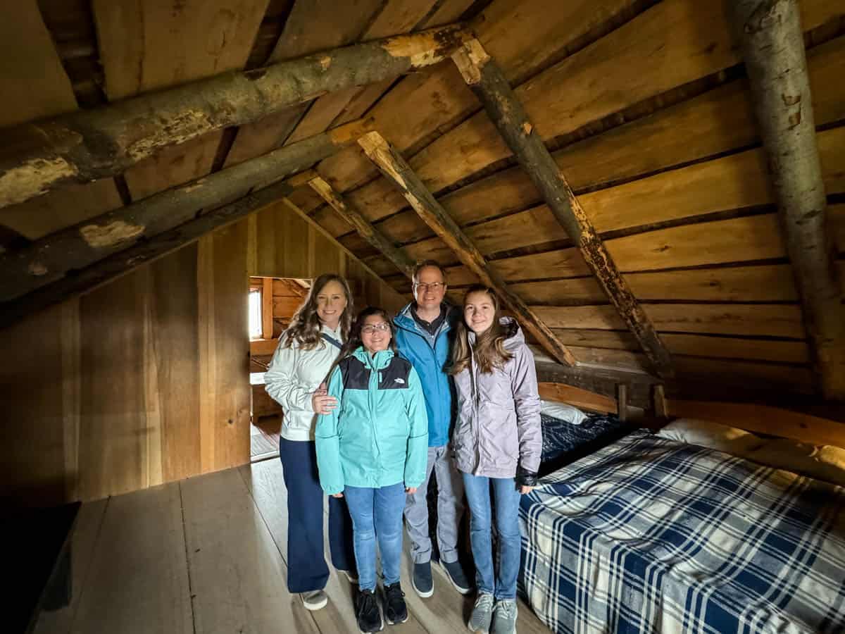 An image of a family in the upper room of the Smith family log home.