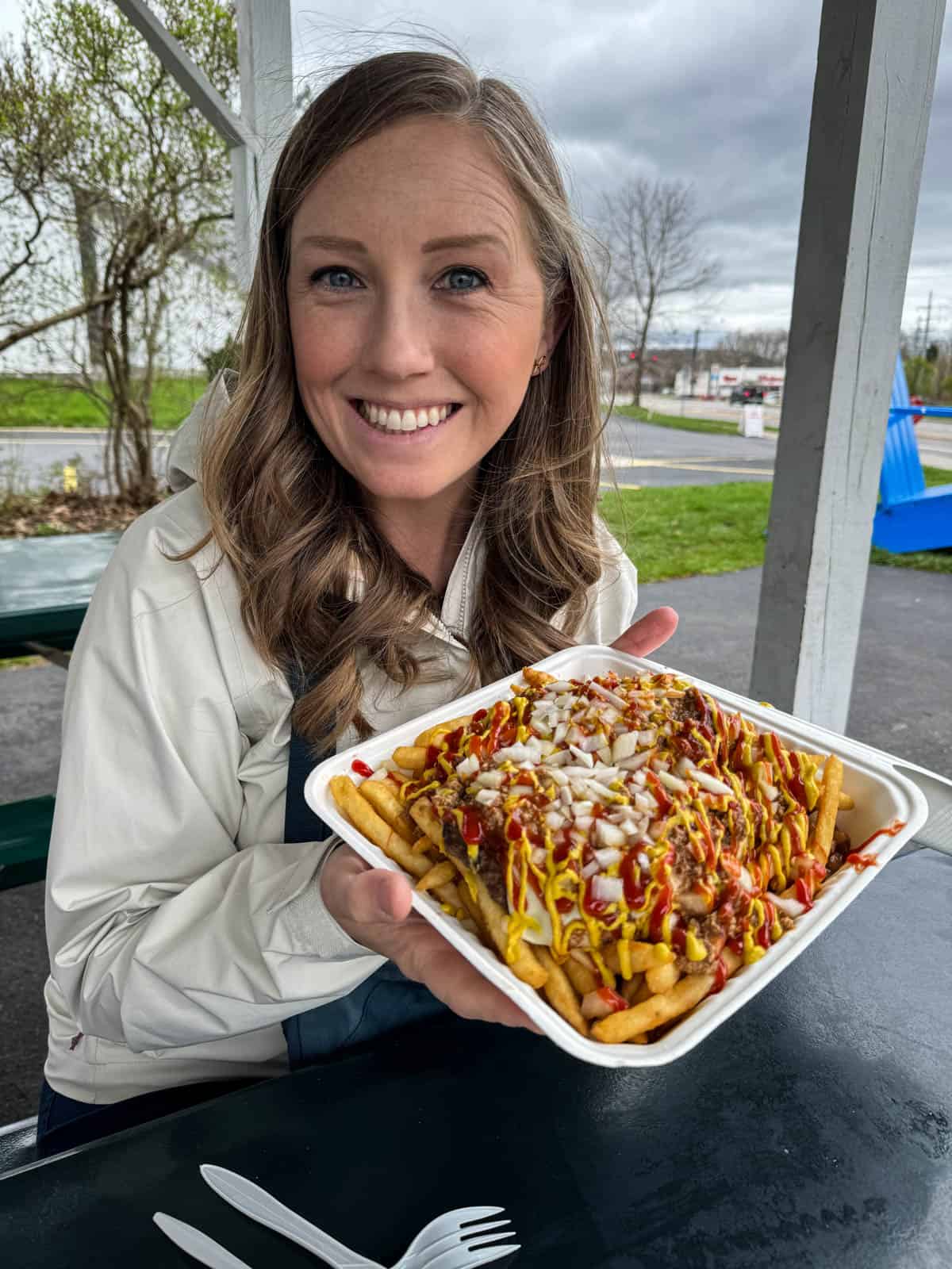 A woman holding a "garbage plate" in upstate New York near Rochester.
