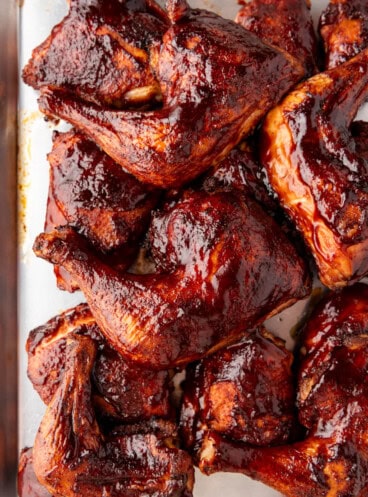 An image of smoked chicken thighs on a baking sheet.