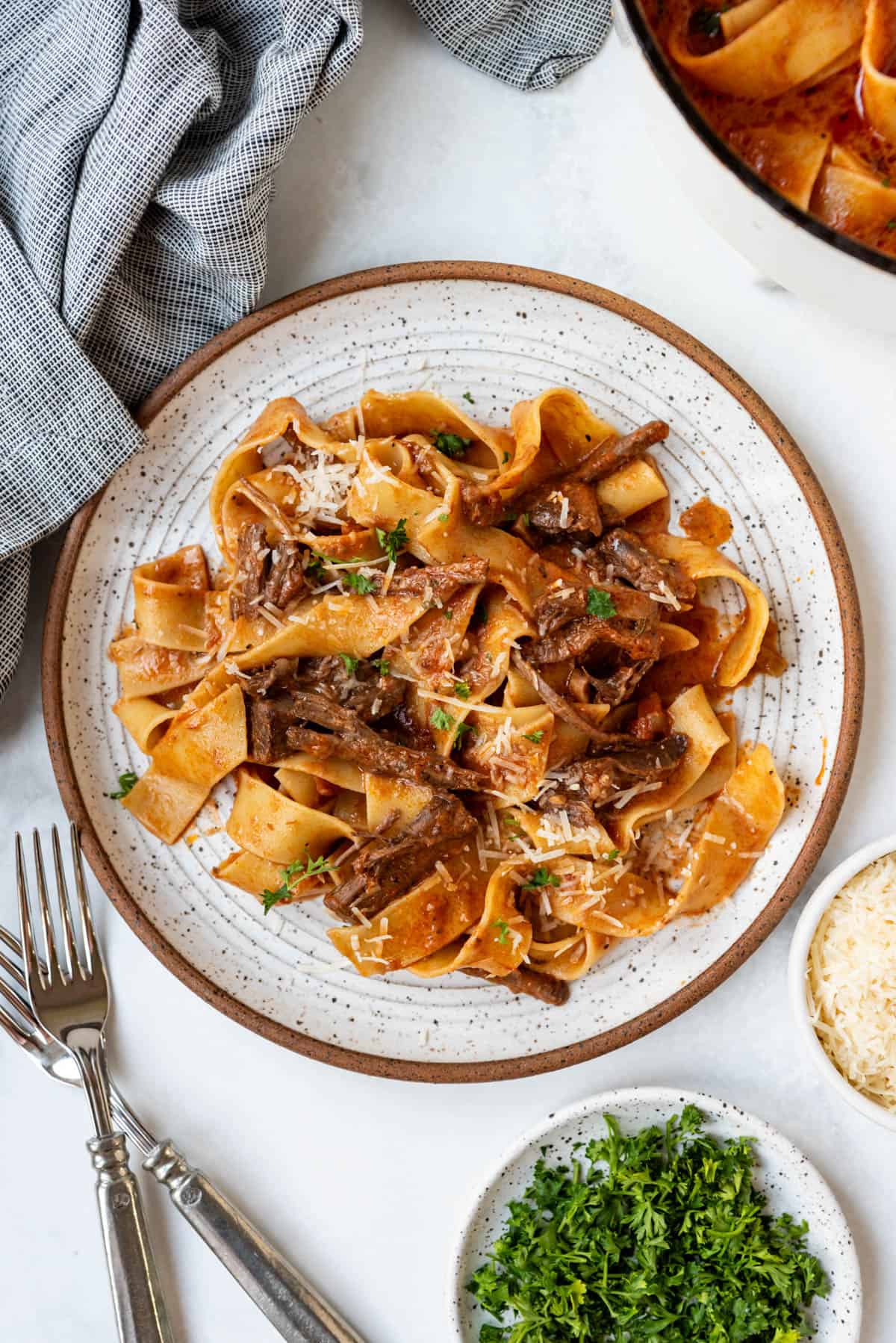 A plate of beef ragu with pappardelle pasta.