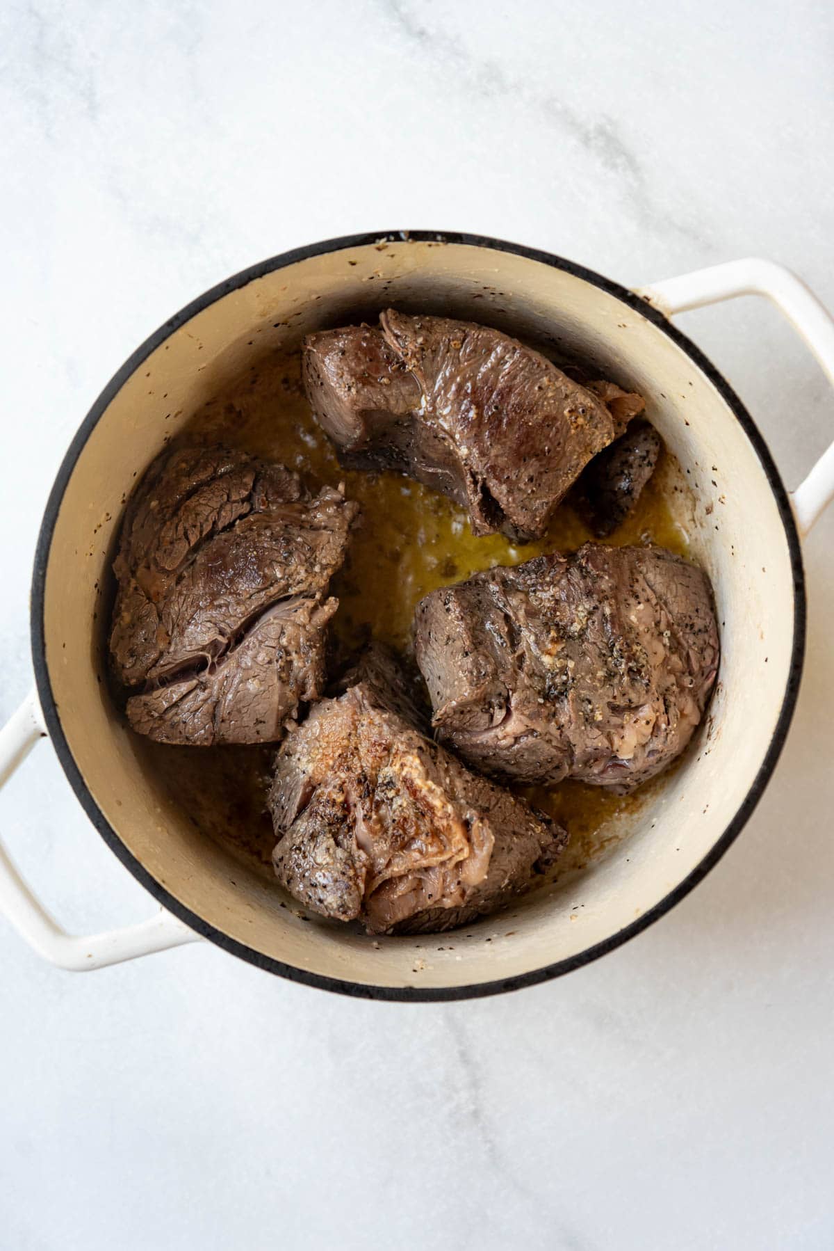 Seared beef chunks in a dutch oven.