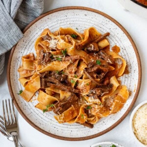 A plate of beef ragu with pappardelle pasta.