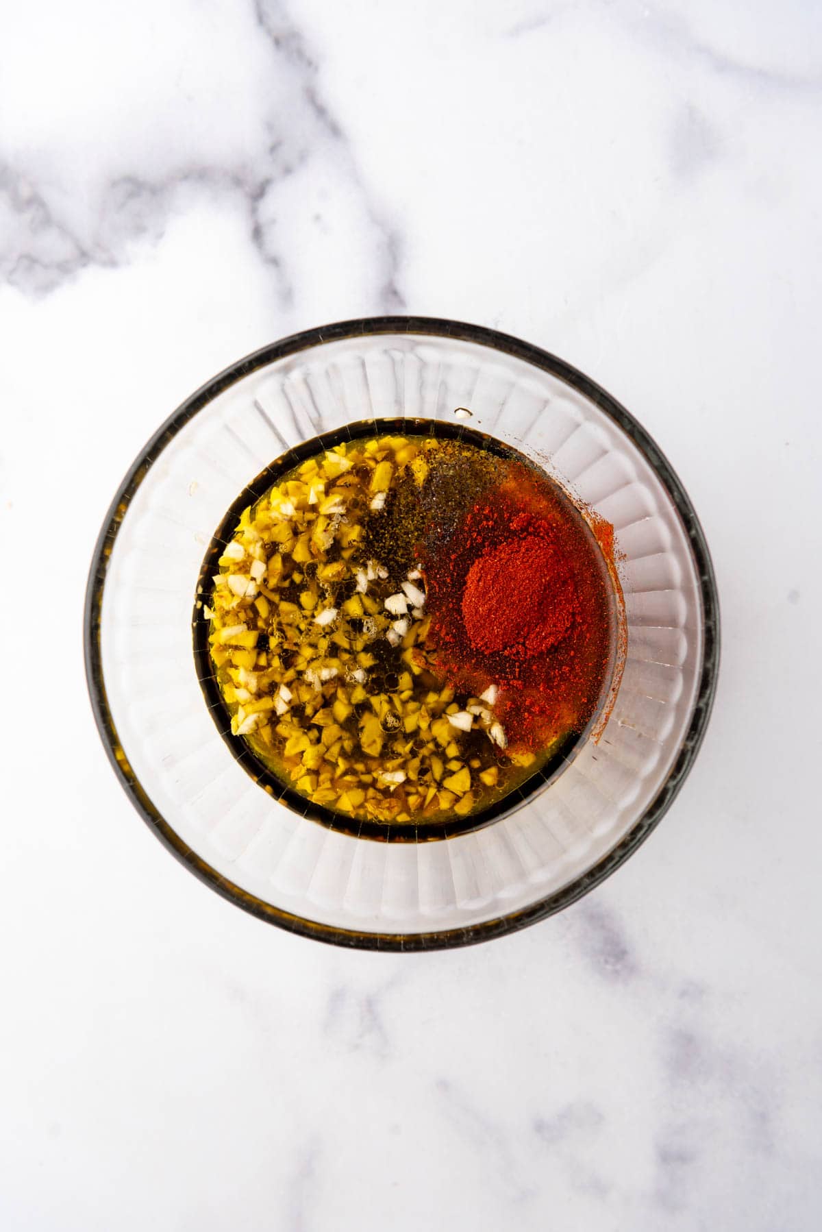 Combining marinade ingredients in a glass bowl.