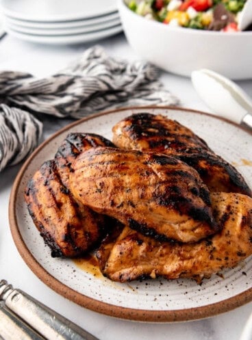 An image of grilled marinated chicken breasts on a plate.