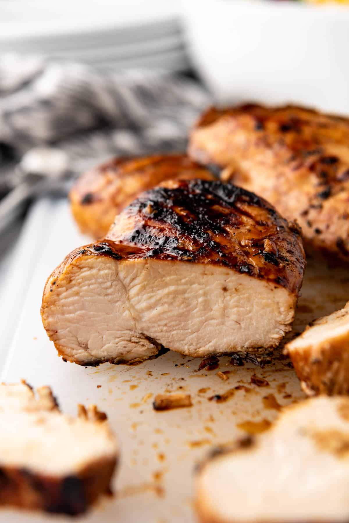 An image of a juicy grilled chicken breast that has been sliced on a cutting board.