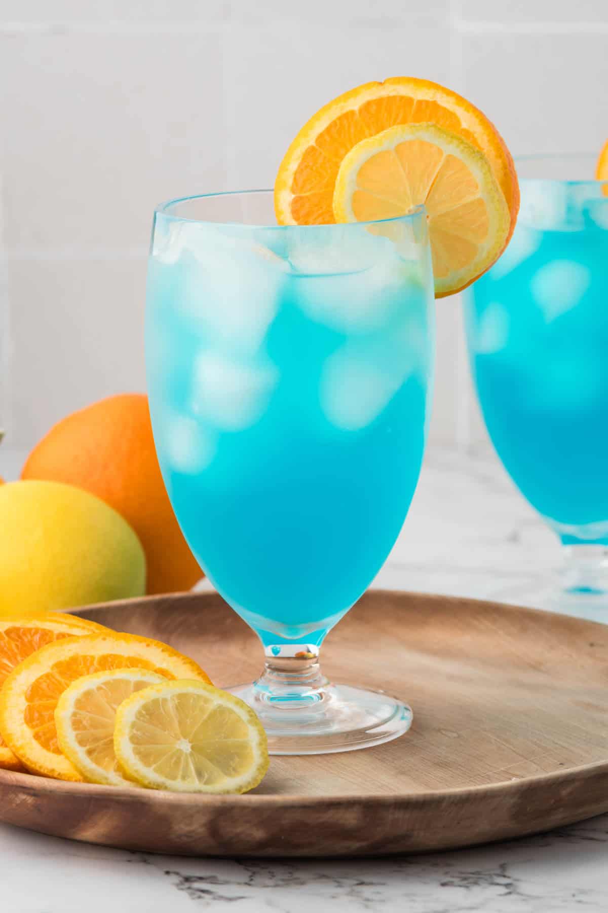 Blue lagoon mocktails with slices of orange and lemon.