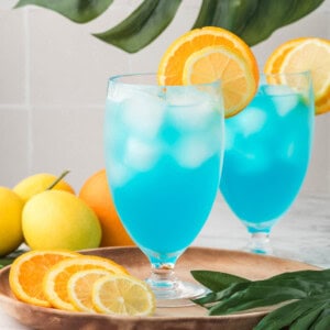 Blue lagoon mocktails with slices of orange and lemon.