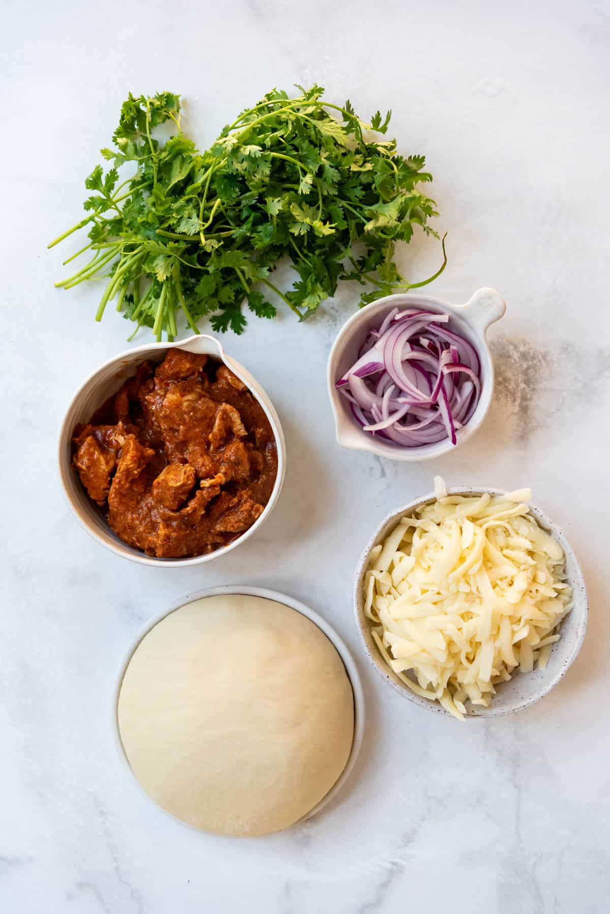 Ingredients for making chicken tikka masala pizza.