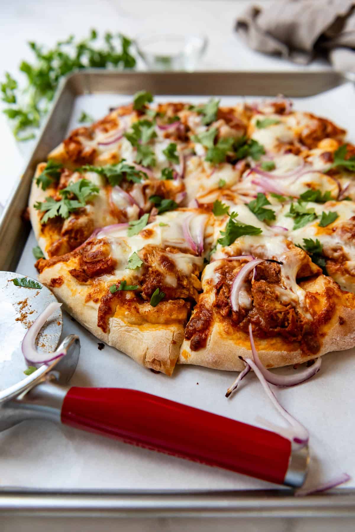 A side view of a pizza on a baking sheet.