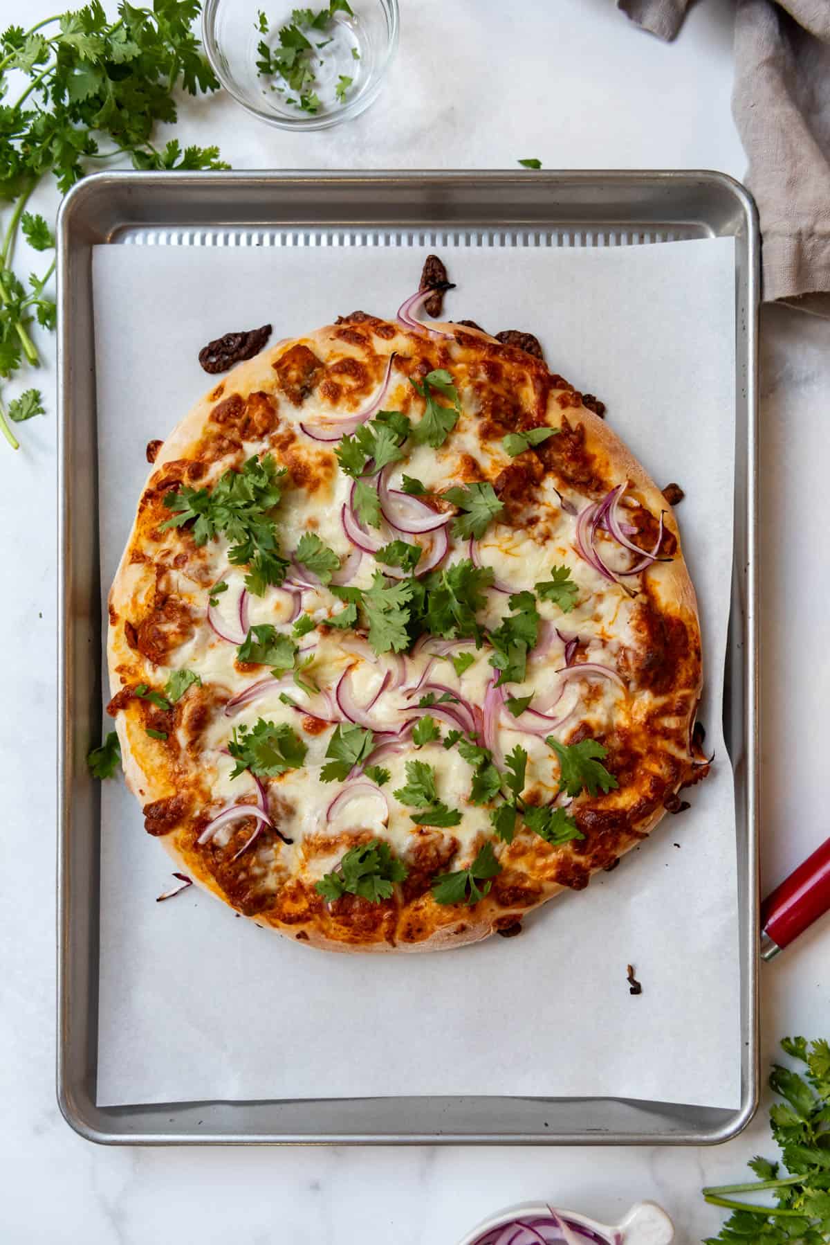 A baked pizza topped with fresh cilantro.