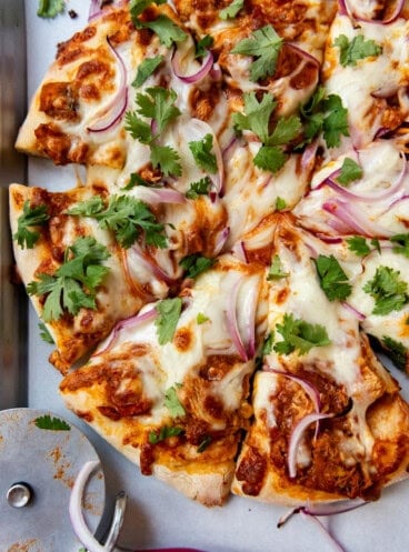 An overhead image of a chicken tikka masala pizza.