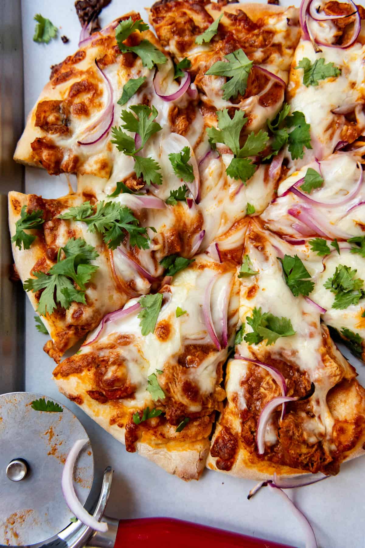 An overhead image of a chicken tikka masala pizza.