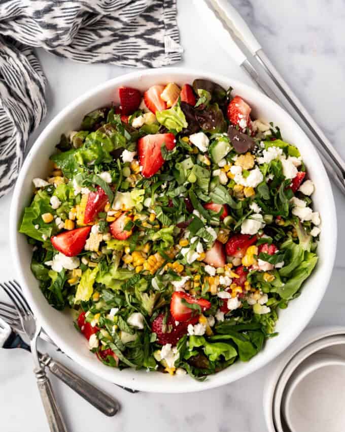 An overhead image of a large serving bowl of strawberry corn summer salad.