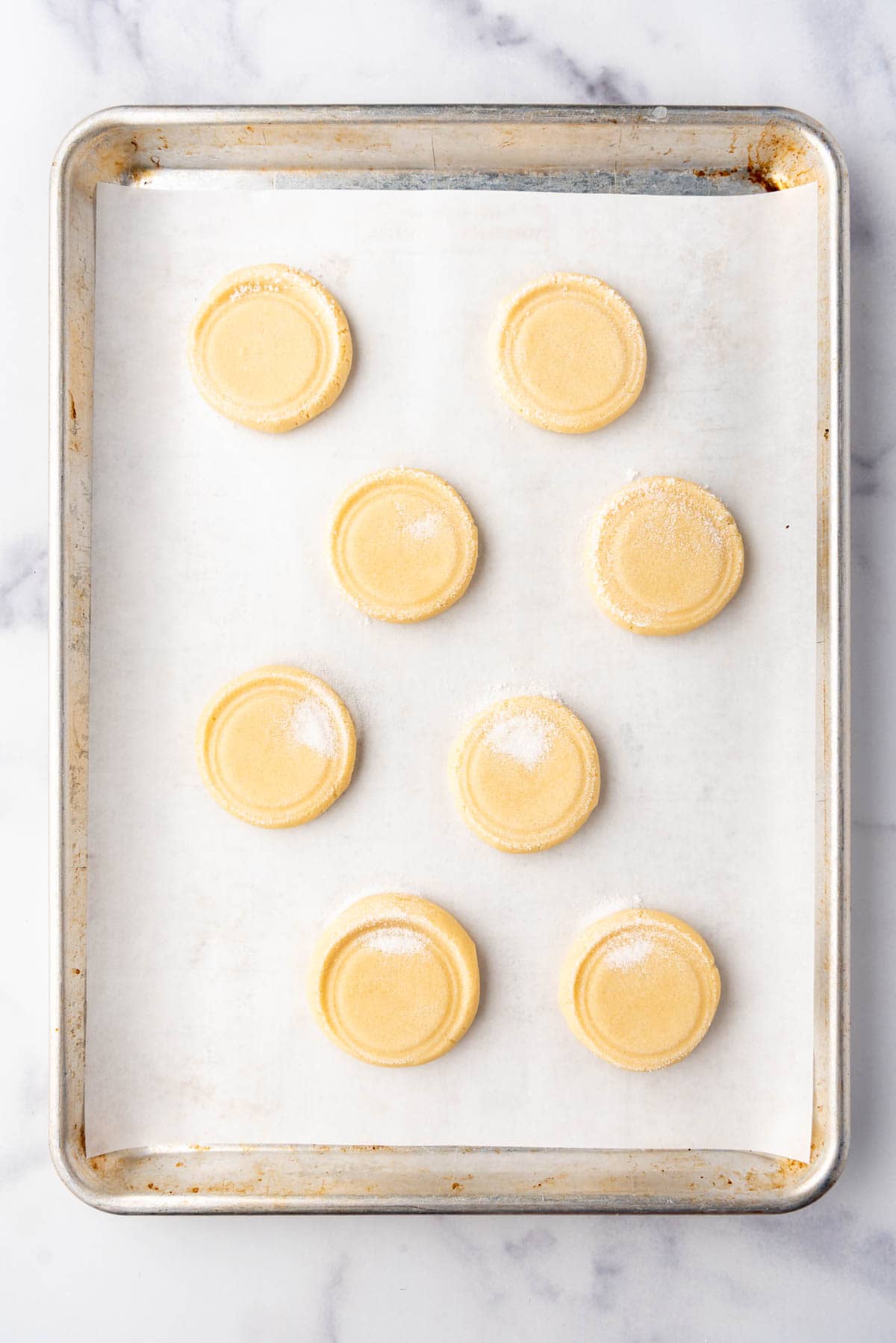 An overhead image of sugar cookie dough on a baking sheet ready to go in the oven.