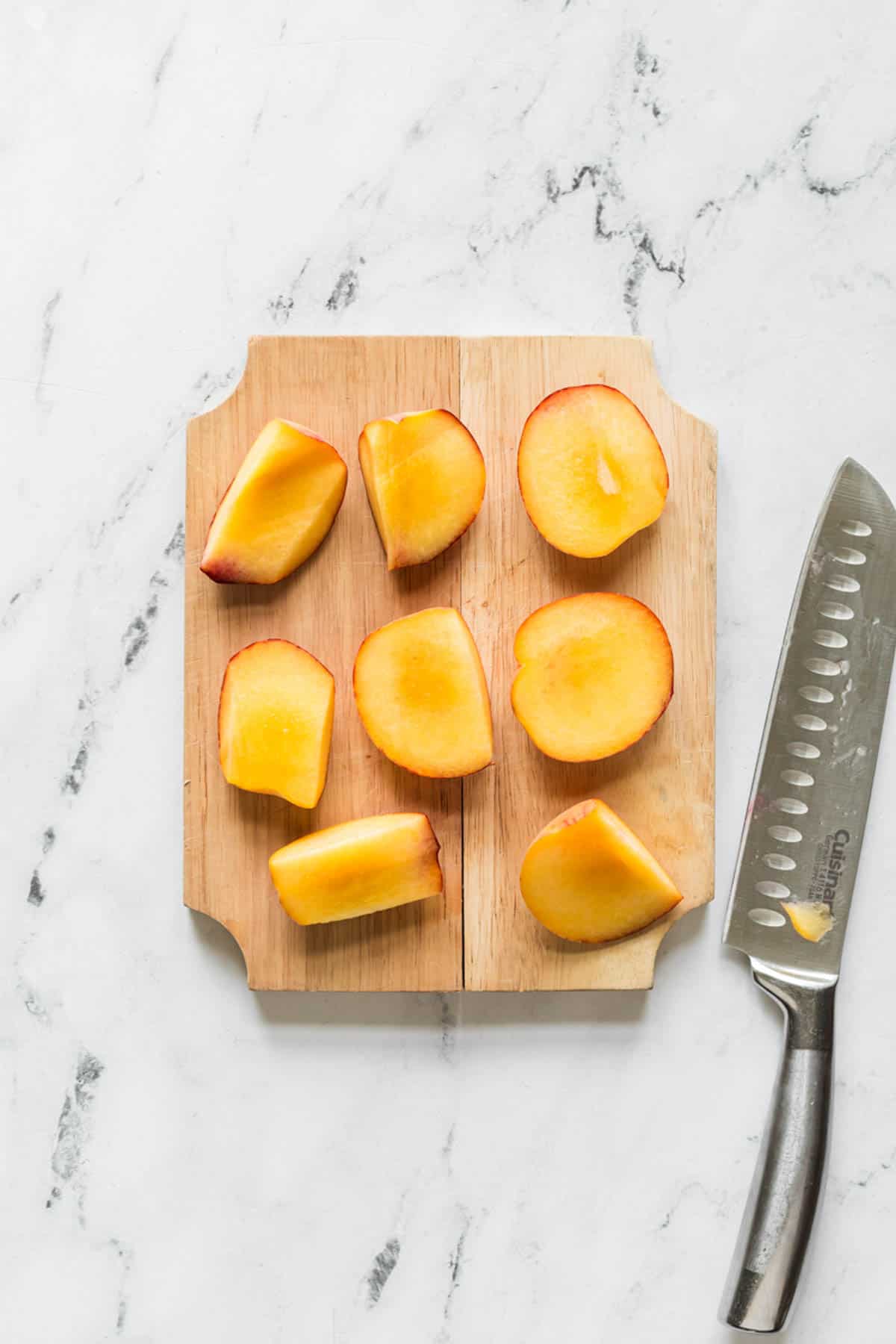 Sliced peaches on a cutting board.