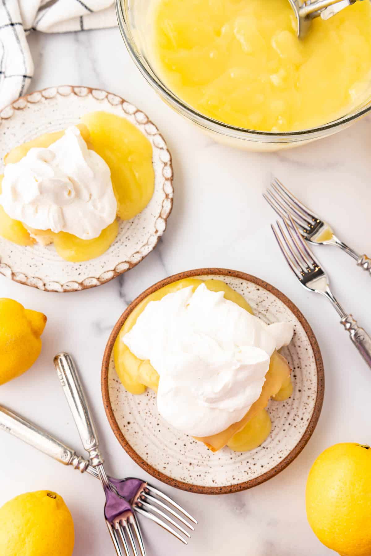 An overhead image of two plates with cake and lemon pudding on it.