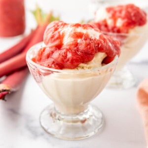 A cup of vanilla ice cream topped with warm rhubarb sauce.