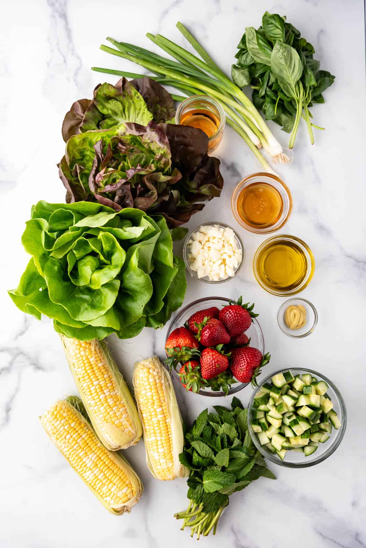 An overhead image of ingredients for making a summer strawberry corn salad.