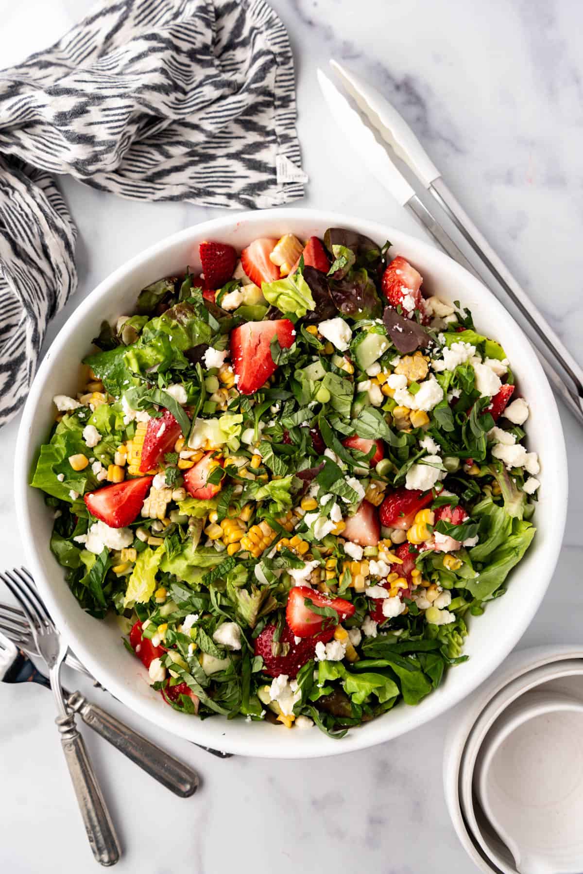 An overhead image of a large serving bowl of strawberry corn summer salad.