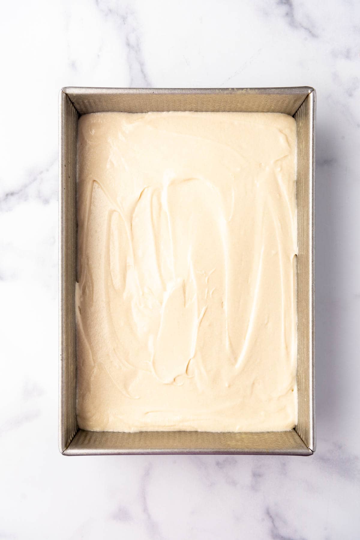 White cake batter in a rectangular sheet pan.