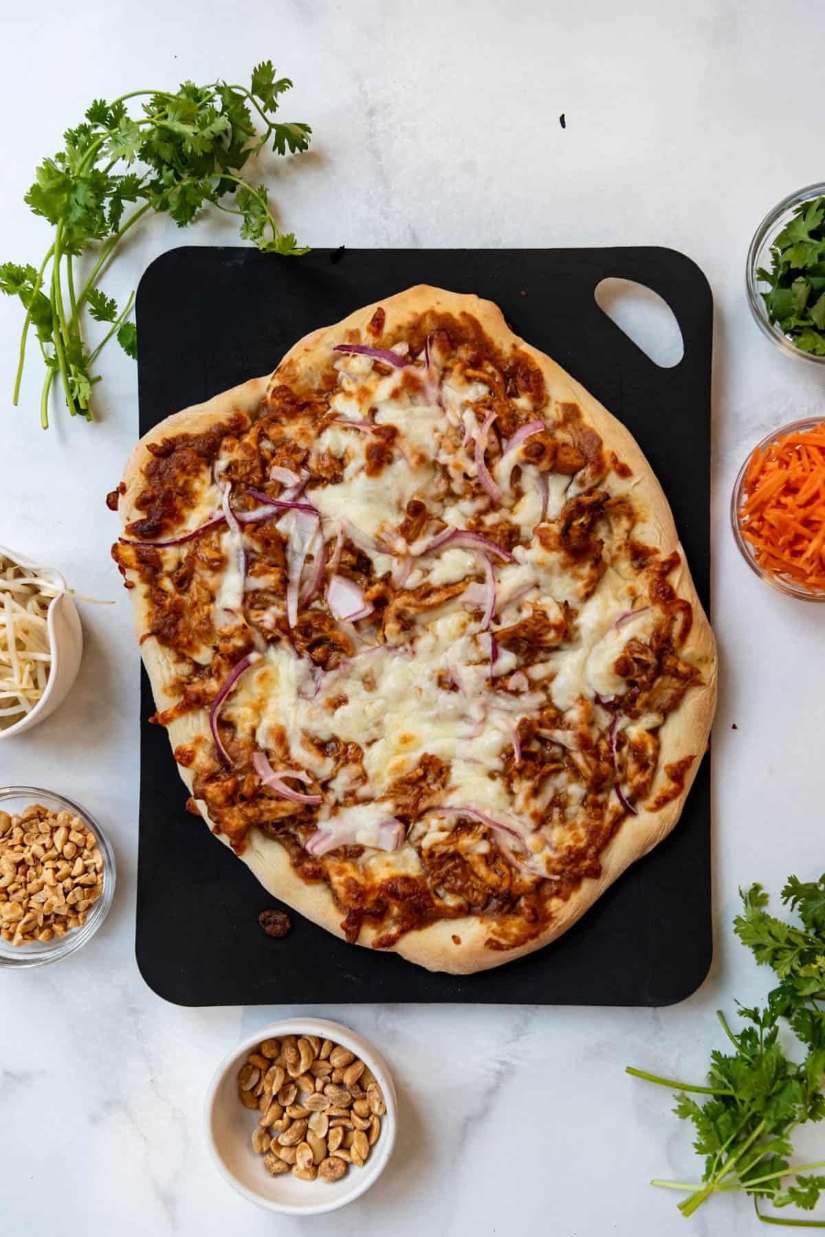 A baked pizza on a black cutting board.