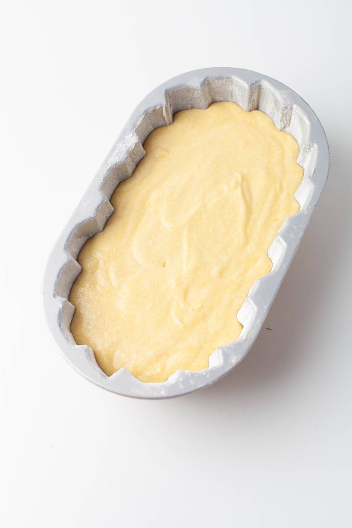 Overhead view of batter in a decorative loaf pan.