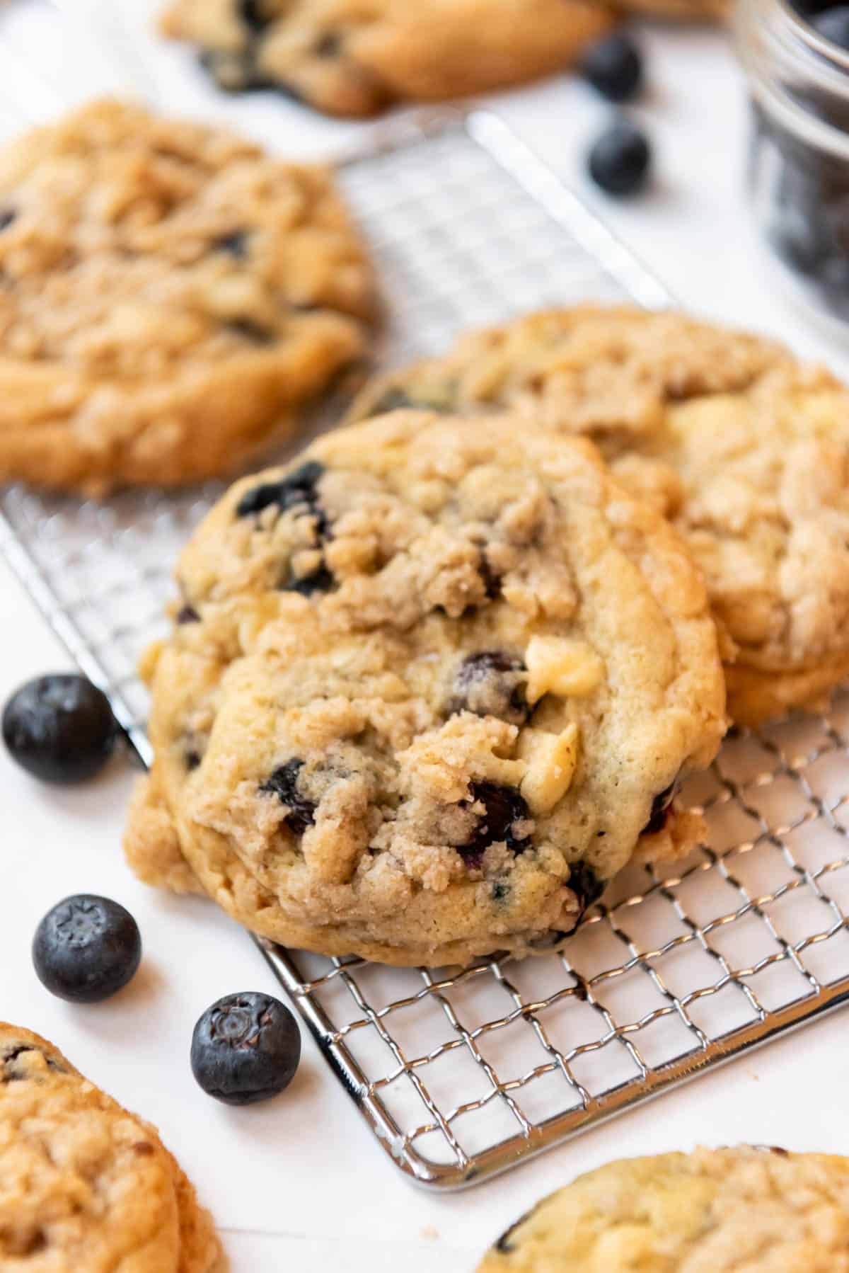 An image of blueberry muffin cookies on a wire cooling rack.