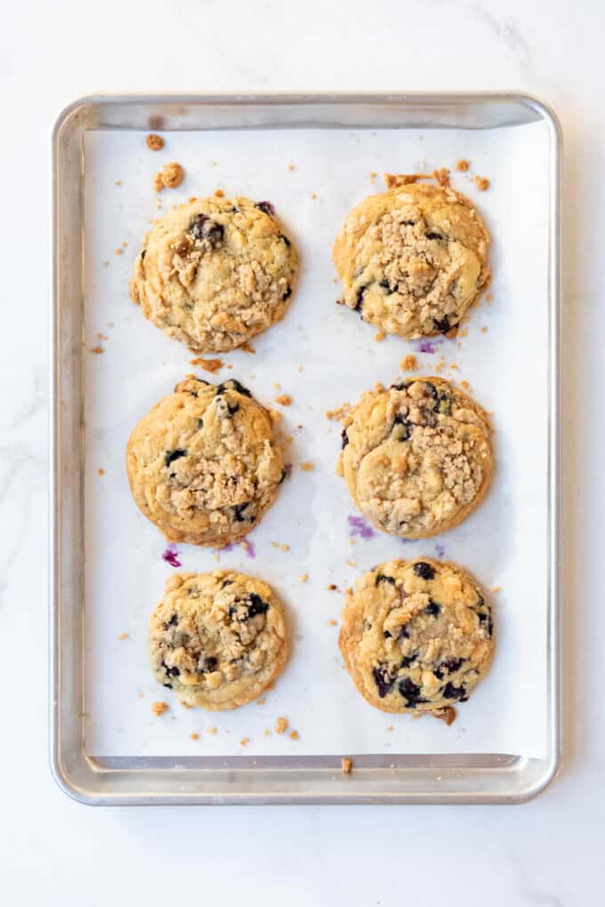 Baked blueberry muffin cookies on a baking sheet lined with parchment paper.