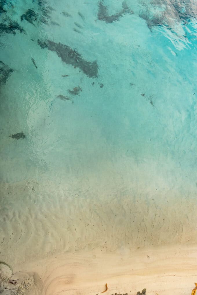 An artistic image of blue water meeting white sand.