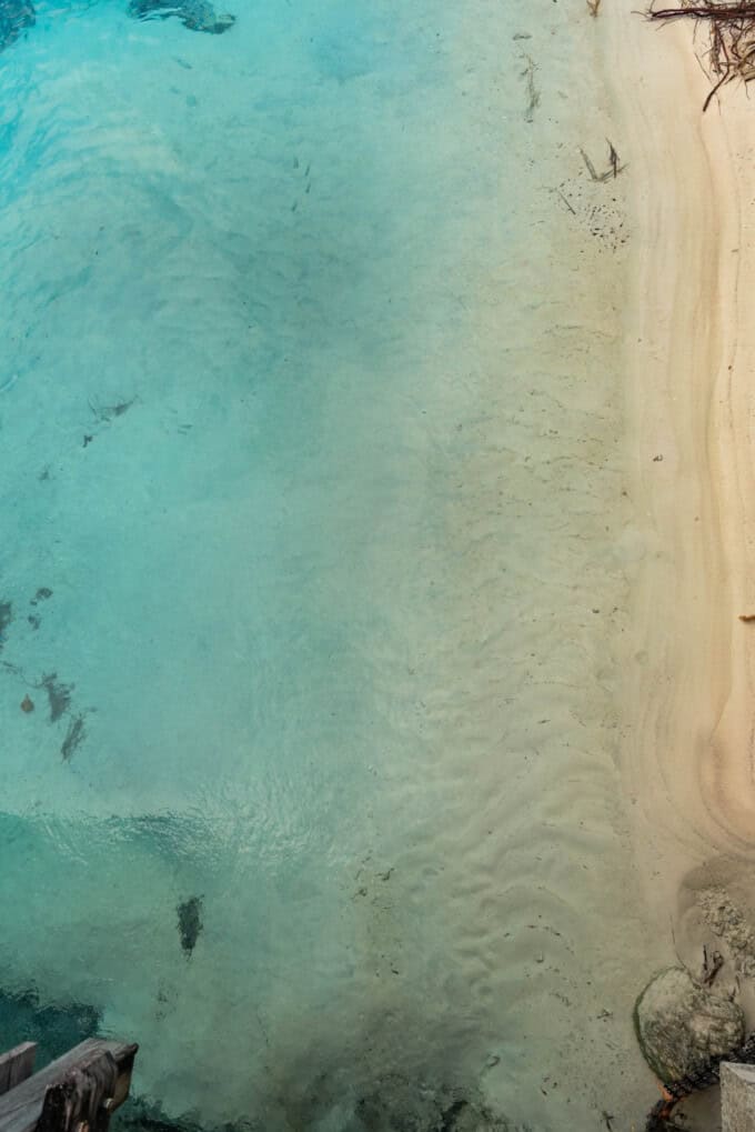 An artistic image of blue water meeting white sand.